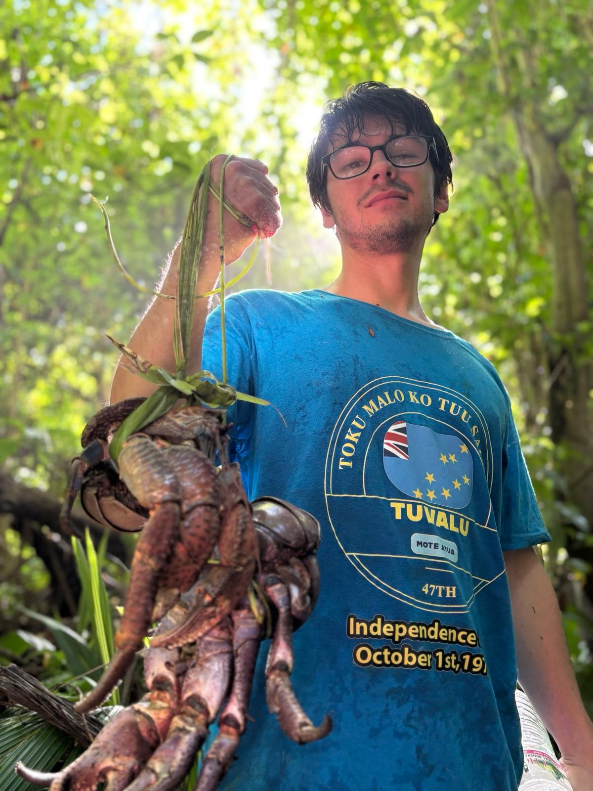 Nick Miller holding a coconut crab in Tuvalu.